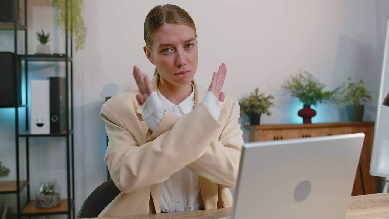 una mujer de negocios enojada dice que no, sostiene la palma, cruza las manos, detente, acceso prohibido, peligro decreciente.