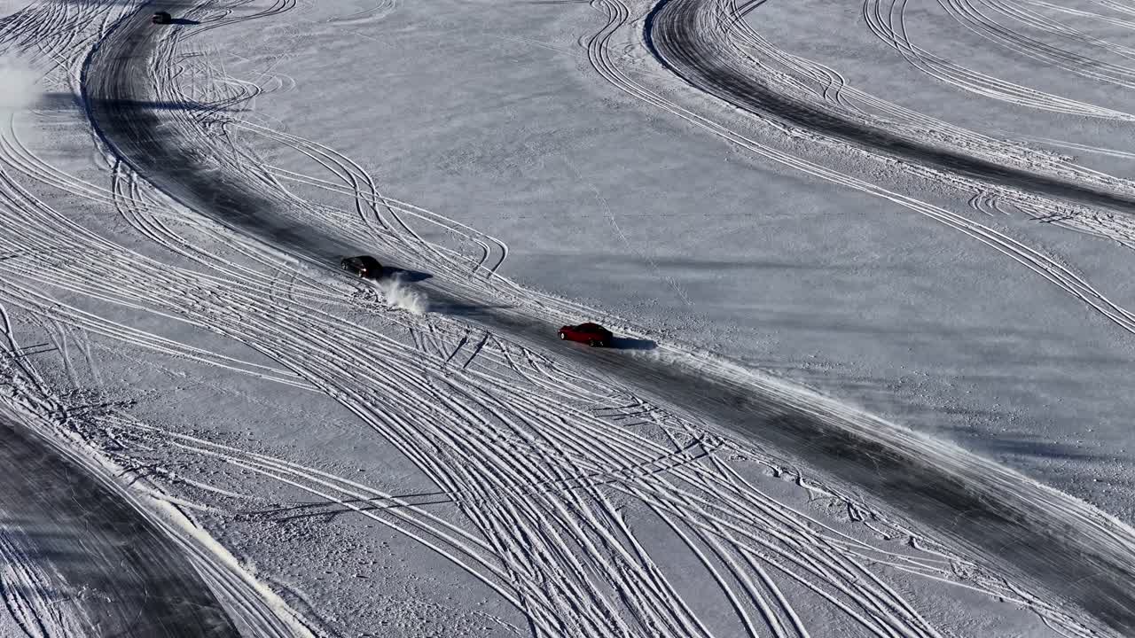 Bil skrider ud i et sving på en isglat vej i slowmotion. Luftfoto.