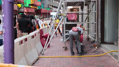 worker operates machinery amidst pedestrian traffic