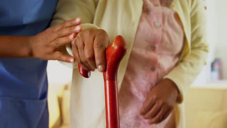 female doctor helping senior woman to walk with walking stick 4k