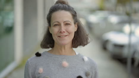 joyful middle aged woman talking to camera.