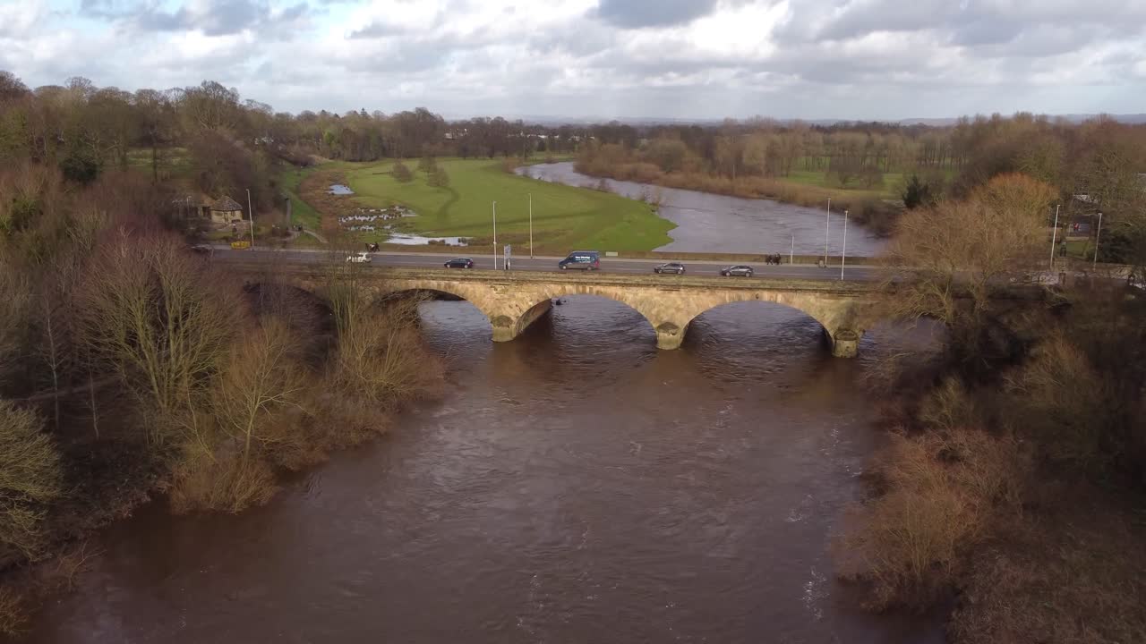 Cinematic pan upwards to Carlisle's Eden Bridge over River Eden with Rickerby Park