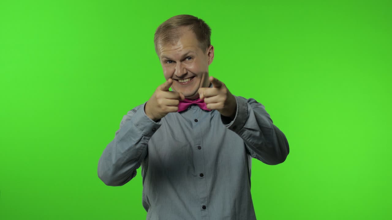 hombre feliz sonriendo a la cámara, riendo despreocupado y señalando con el dedo a la camera, eligiendo algo