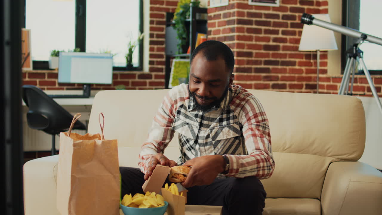 Modern adult having hamburger and fries for dinner