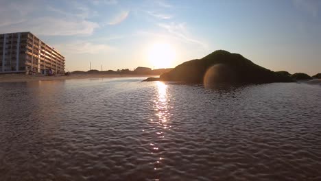 Wellen-Schlagen-Bei-Sonnenuntergang-Gegen-Felsen-Am-Strand