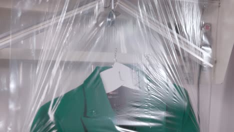mujer empaquetando traje con plástico usando máquina de embalaje para la tienda de lavandería