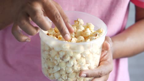 person holding a container of popcorn