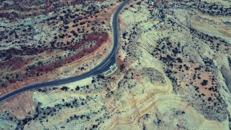 drone view of asphalt road going through sandy valley in utah