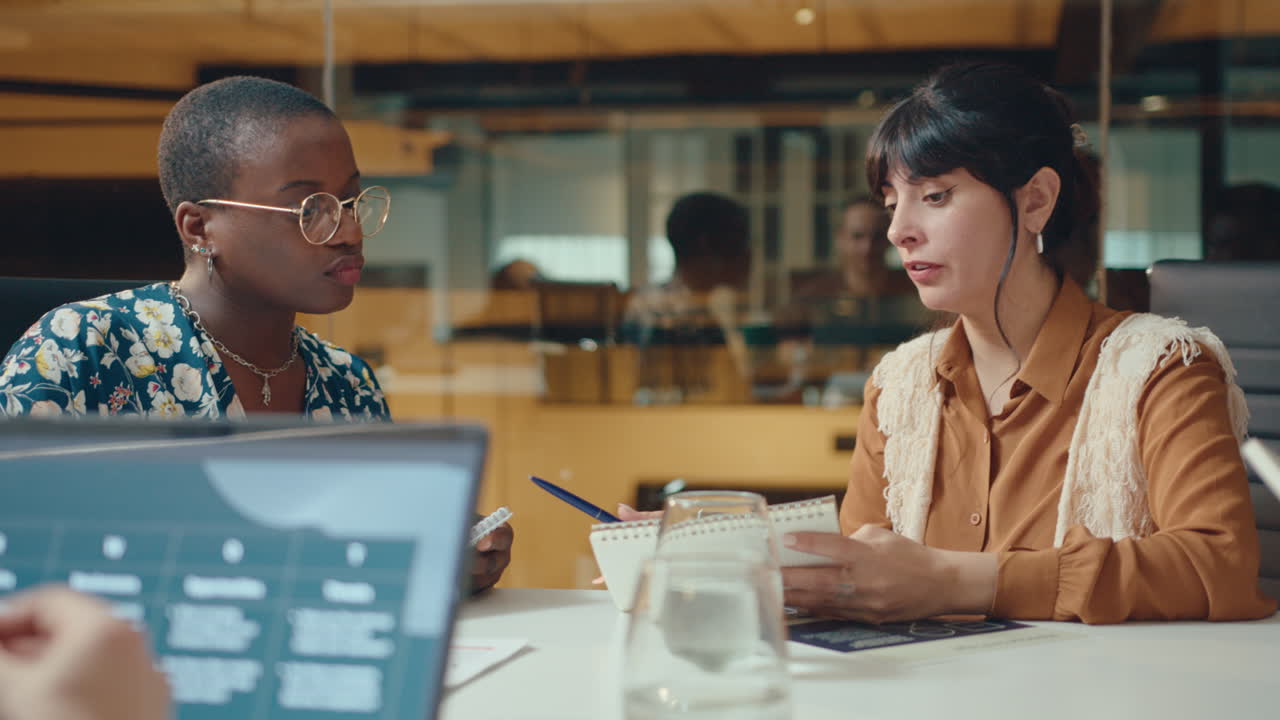 Businesswoman Sharing Ideas with Female Colleague in Office