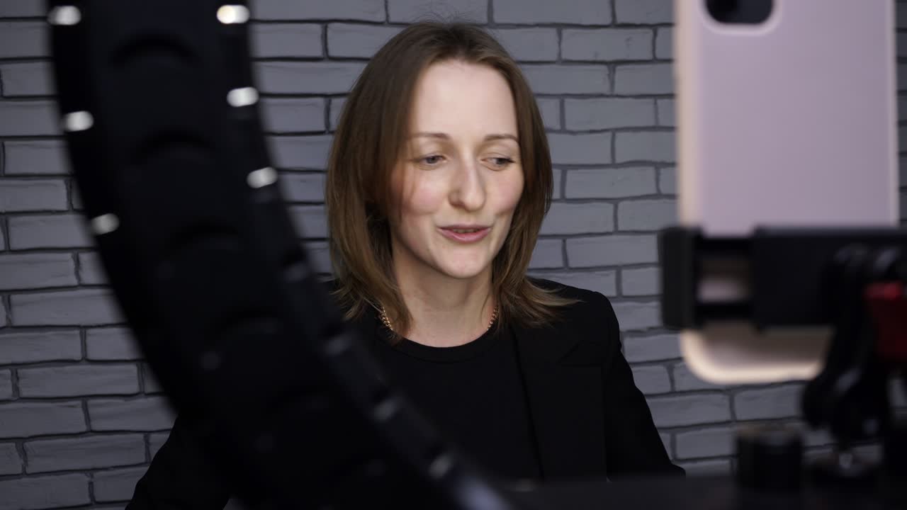 blogger chica historia de tiroteo con lámpara de anillo en el fondo de la pared de ladrillo