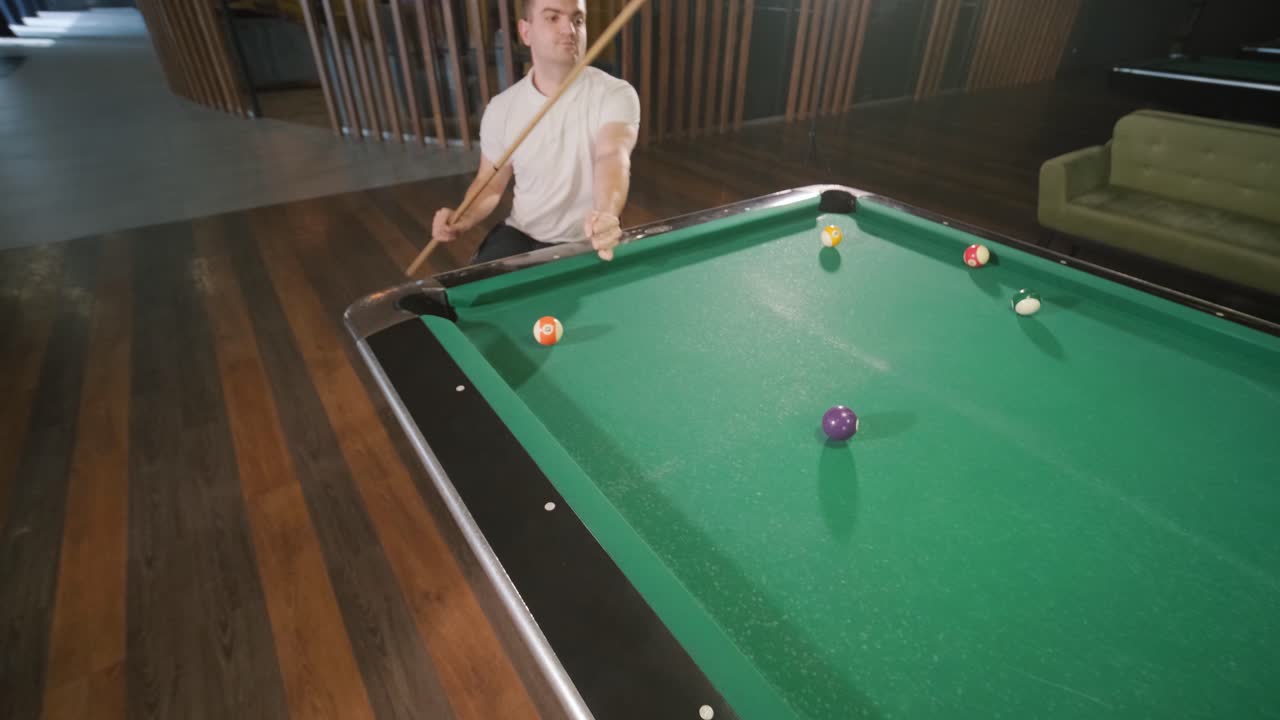 Adult men with disabilities in a wheelchair play billiards in the club