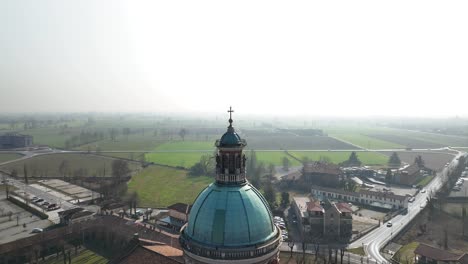 aerial drone shot over a bell tower in a village in the caravaggio sanctuary, lombardy