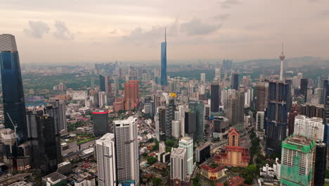 aerial pullback view of iconic skyscrapers towering above kuala lumpur skyline