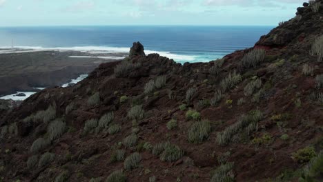 Low-drone-flight-along-mountain-ridges-and-revealing-Atlantic-ocean-swell,-captured-by-drone-in-4K,-48fps