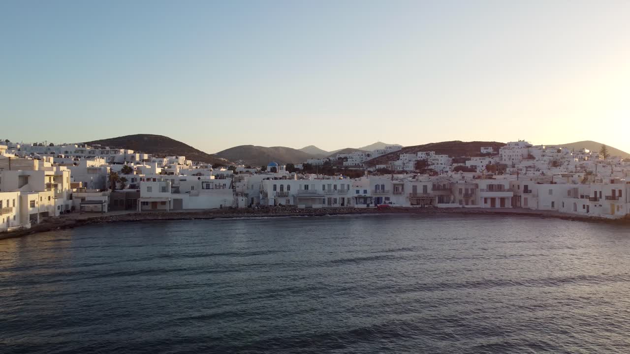 asombrosa foto de acercarse a la pintoresca playa pequeña y al pueblo naoussa de paros durante la puesta de sol de verano en grecia desde el mar