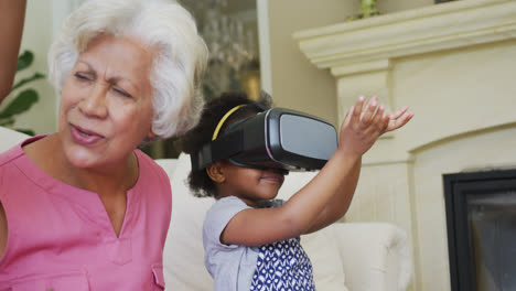 Feliz-Abuela-Afroamericana-Con-Nietas-Usando-Auriculares-Vr-En-La-Sala-De-Estar