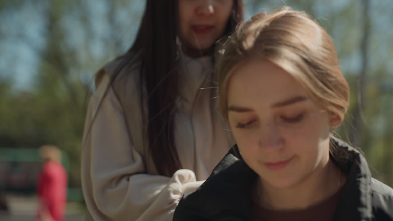 친구들이 작은 배려를 나누고, 화창한 야외에서 여성들이 사려 깊은 행동을 하며, 평화로운 야외 환경에서 액세서리를 교환하며 따뜻함과 친절함을 보여주고 있어요.