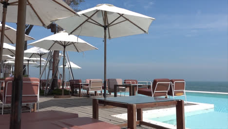 chair and umbrella with swimming pool and sea beach background