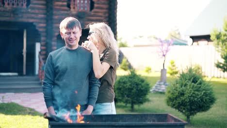 Ein-Junger-Mann-Reist-Mit-Einem-Mädchen,-Das-Neben-Dem-Grill-Steht,-In-Dem-Kohlen-Rauchen