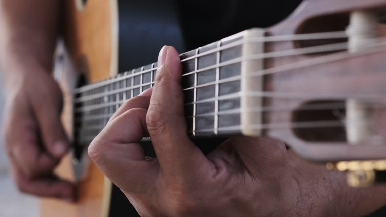 tocando la guitarra, vista única desde la mano que rasguea hasta la mano que se preocupa y viceversa