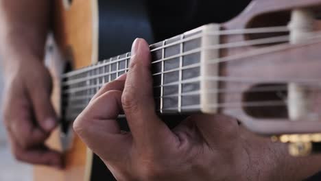 tocando la guitarra, vista única desde la mano que rasguea hasta la mano que se preocupa y viceversa