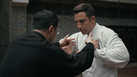 two men practicing tai chi or qigong outdoors