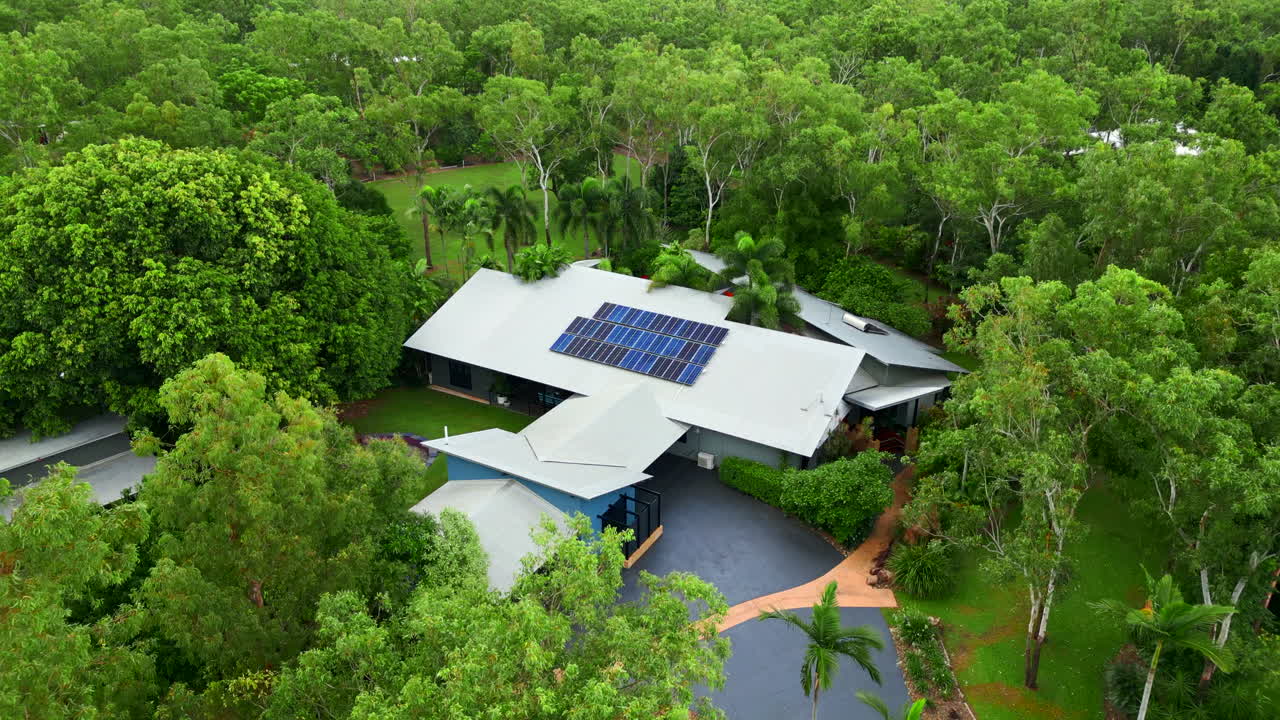 Vista Aerea di una Casa Moderna con Pannelli Solari in un Lussureggiante Contesto Tropicale