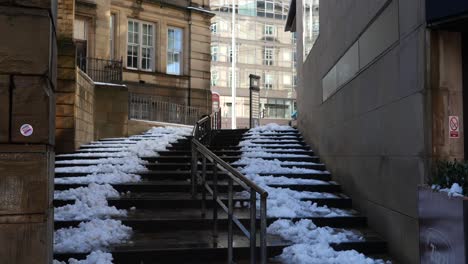 Snowy,-frozen-steps-in-city-back-alley-on-sunny-day,-Sheffield