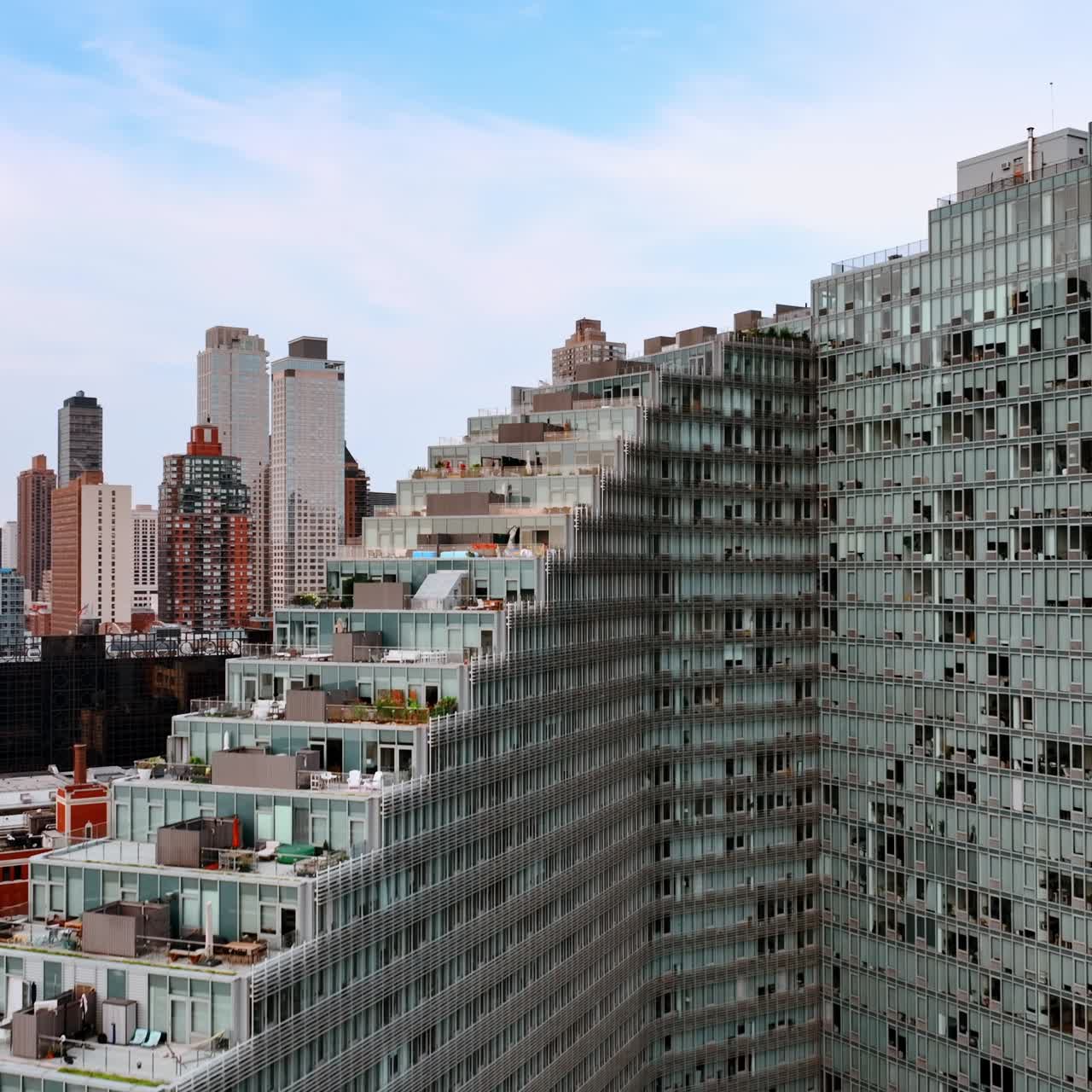 Staircase design of the huge grey multistoried building of New York. Lounge zones, car parks on the tops of the houses. Skyscrapers at backdrop