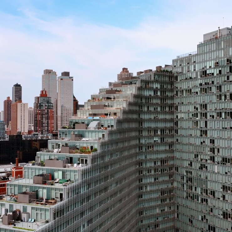 Design della scalinata dell'enorme edificio grigio a più piani di New York. Zone lounge, parcheggi sulla sommità degli edifici. Grattacieli sullo sfondo