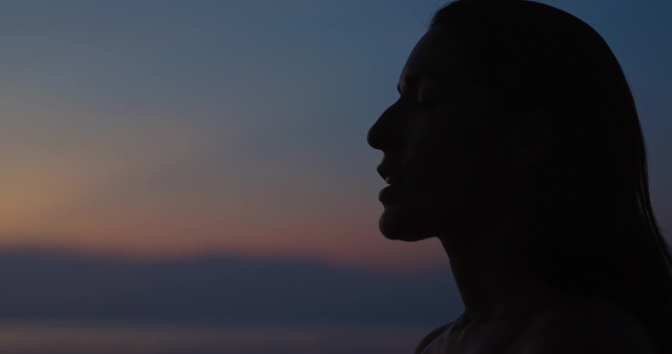 Silhouette of a Woman Meditating at Sunset