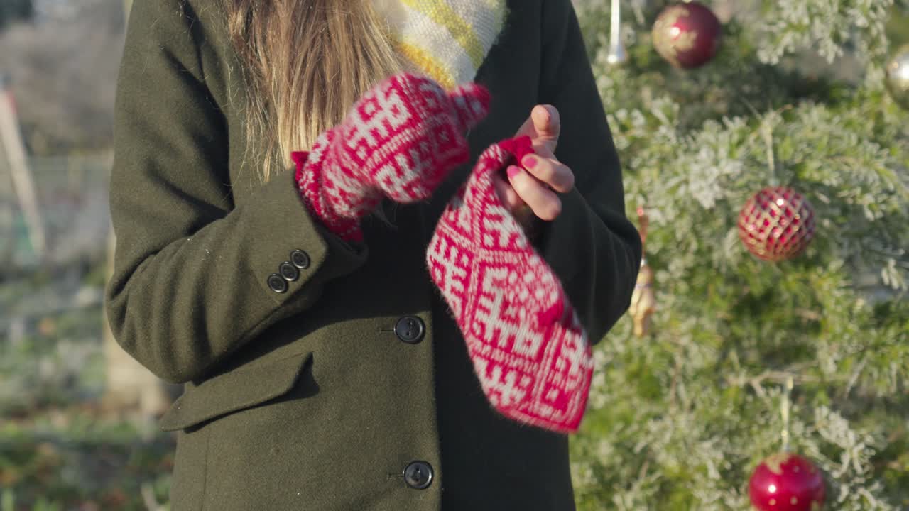 추운 화창한 크리스마스 날에 빨간 니트 장갑을 끼고 금발 여자