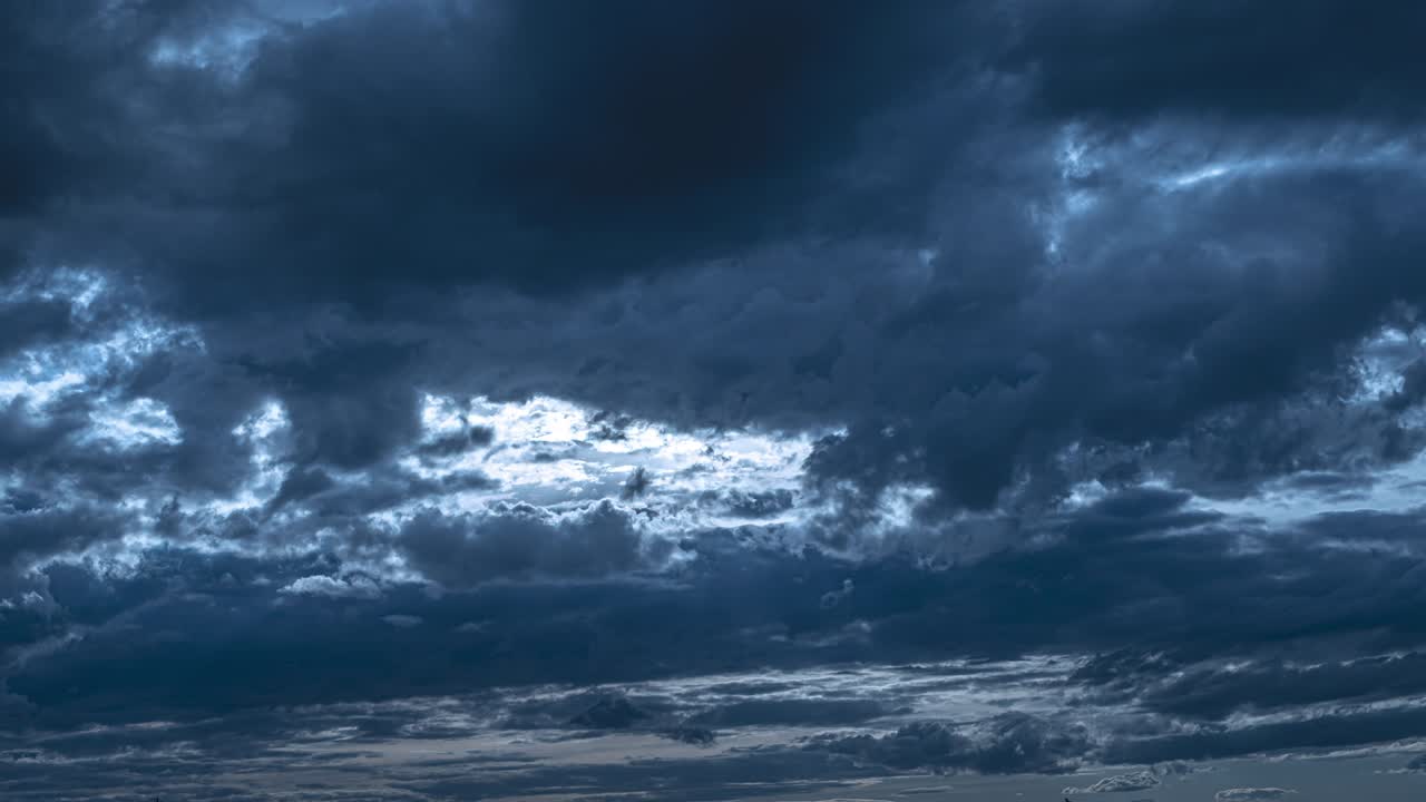 깊은 파란 구름이 저녁 하늘을 흐르고 있습니다.