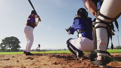 diverse group of female baseball players playing on the field, hitter hitting pitched ball