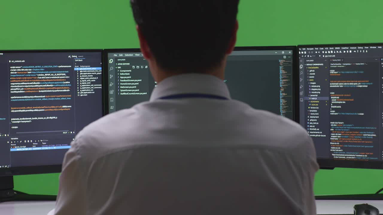 Programmer working on code on multiple monitors