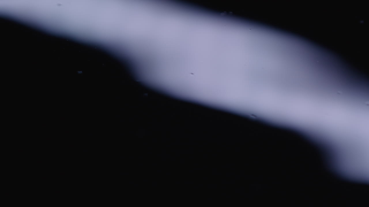 여전히 검은 액체의 매크로 이 물결을 일으키기 시작합니다.