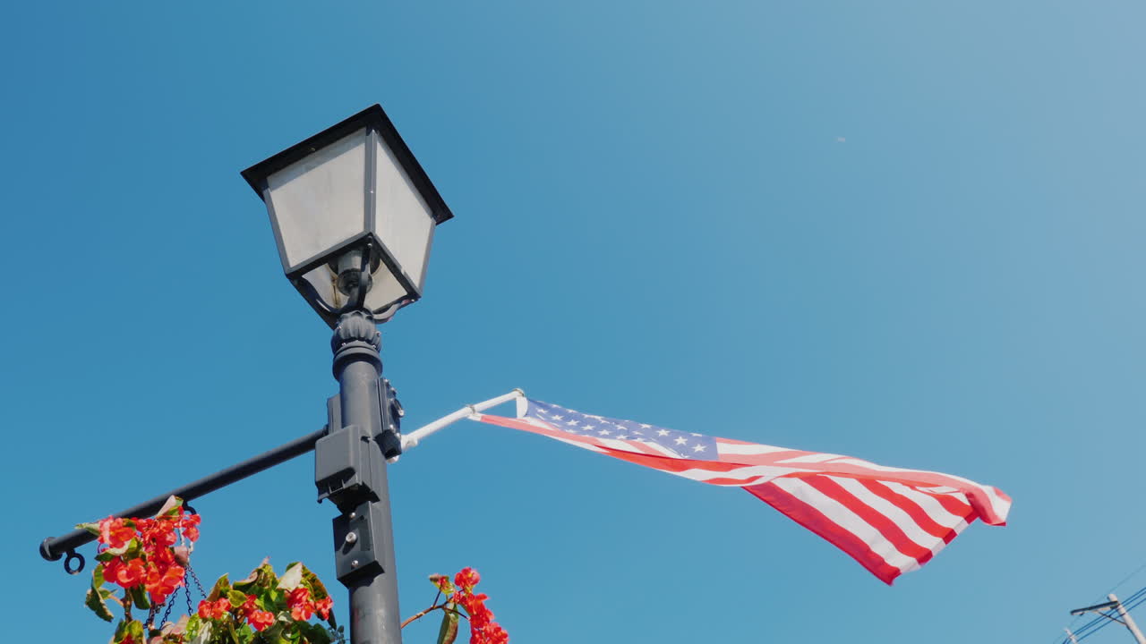 꽃과 미국 국기가 있는 가로등 기둥