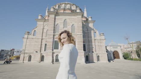 beautiful woman goes to mosque. action. rear view of beautiful woman walking in front of mosque. attractive woman walks into mosque on sunny day in istanbul