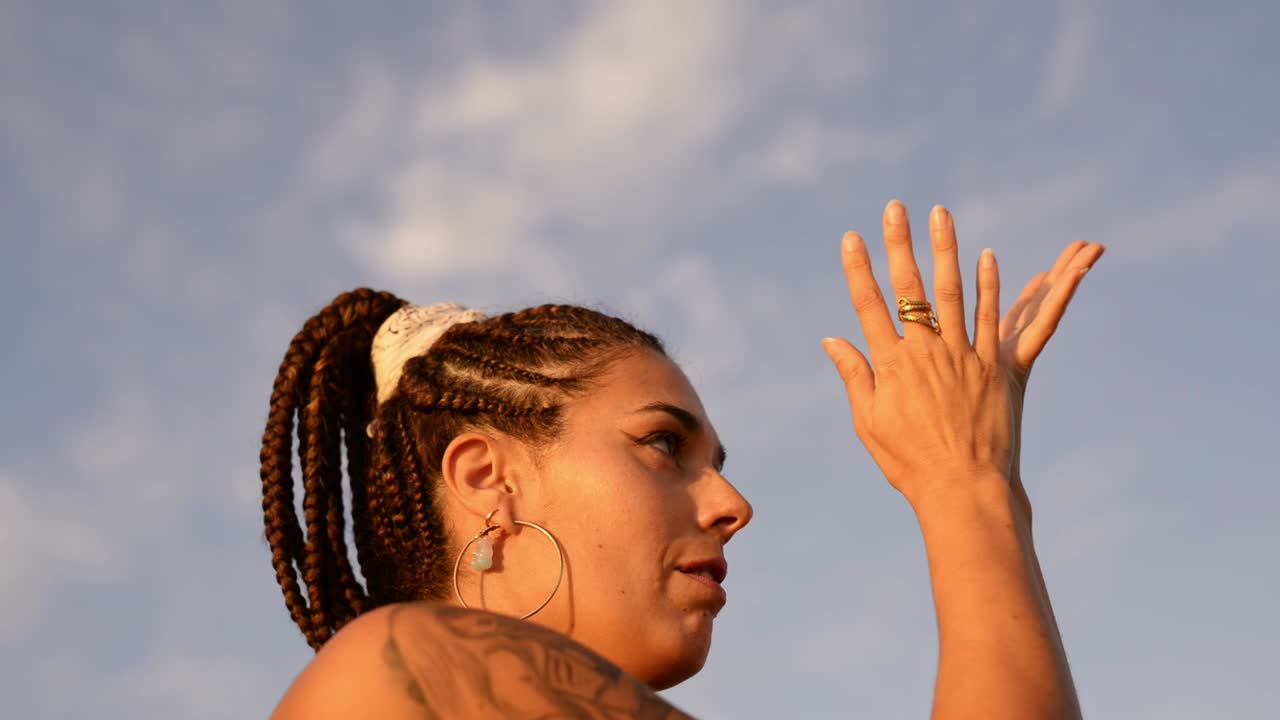 Donna adulta che balla sotto un cielo nuvoloso.