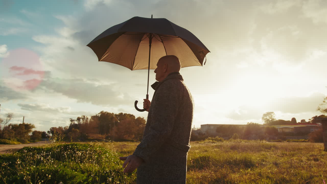 Old Bald Man Under an Umbrella on a Sunny Day in Nature
