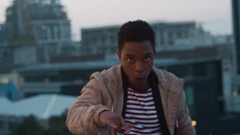 happy african american man posing making funny faces enjoying rooftop celebration  at sunset having fun crazy weekend in city