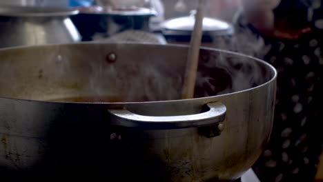 Female-Chef-Throwing-In-Powder-Spices-To-Steaming-Large-Pot-In-Kitchen