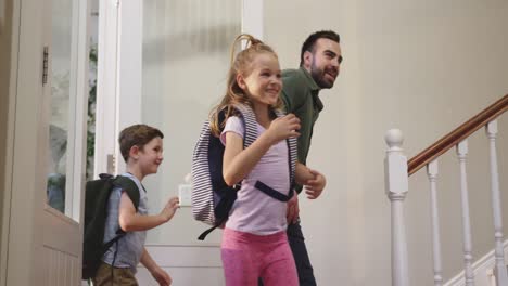 familia caucásica entrando por la puerta principal de su casa