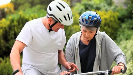 pareja madura montando en bicicleta afuera