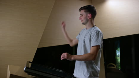 young man in front of a touch screen, making hand gestures in the air, handheld