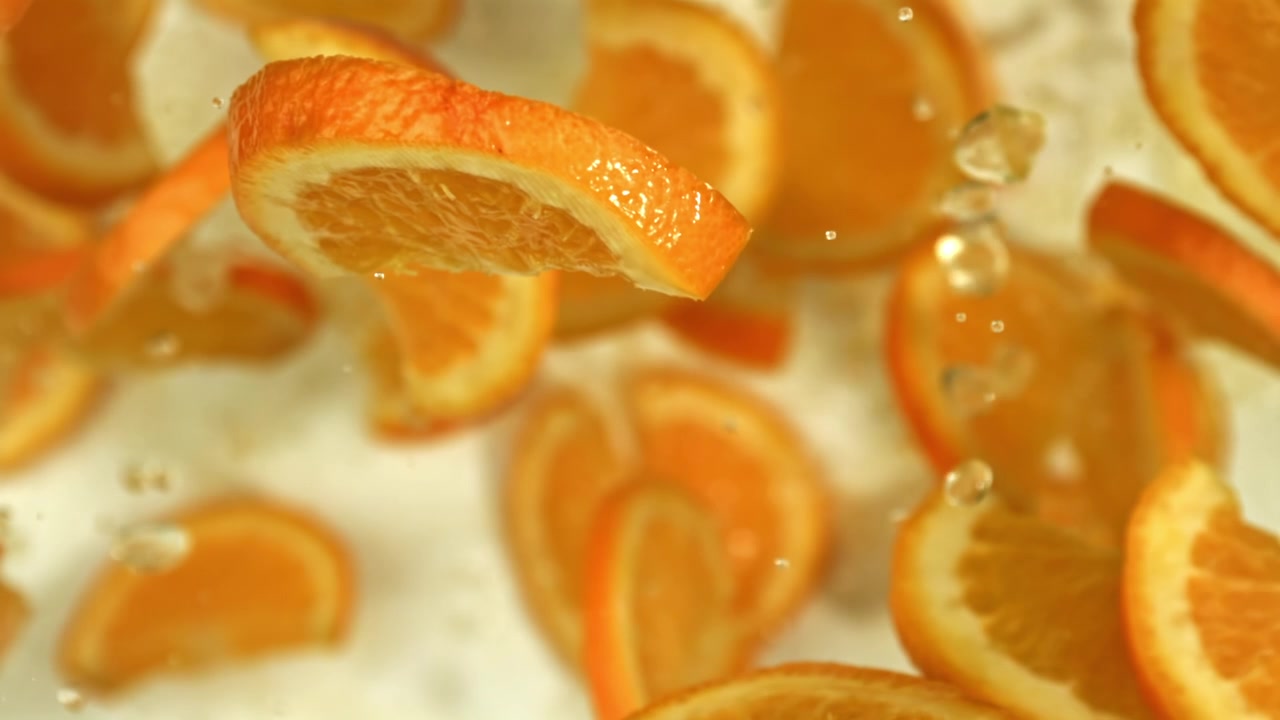 Fresh Orange Slices Floating and Splashing in Water