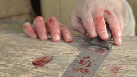 agotadas manos manchadas de sangre buscando un cuchillo manchado de sangre