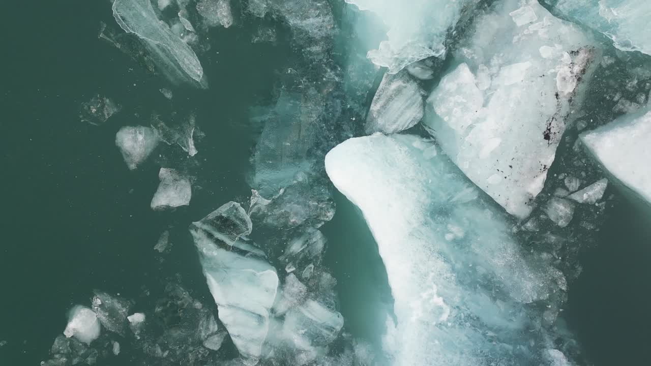 Ripresa con drone di pezzi di ghiaccio che galleggiano sull'acqua in Islanda durante l'inverno