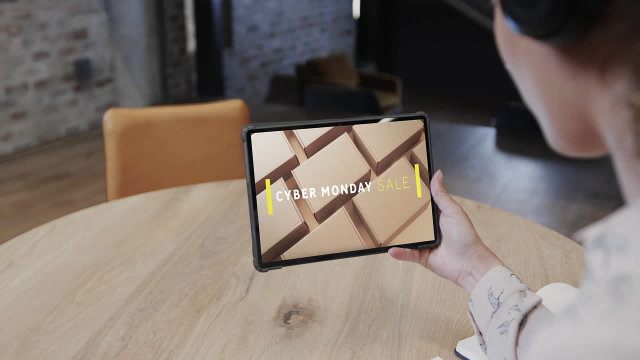 Biracial woman using tablet at cafe for online shopping, slow motion