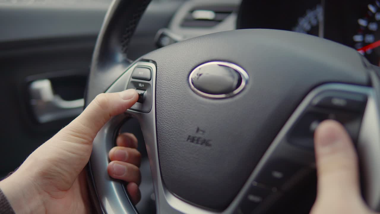 persona que utiliza los controles del volante del automóvil